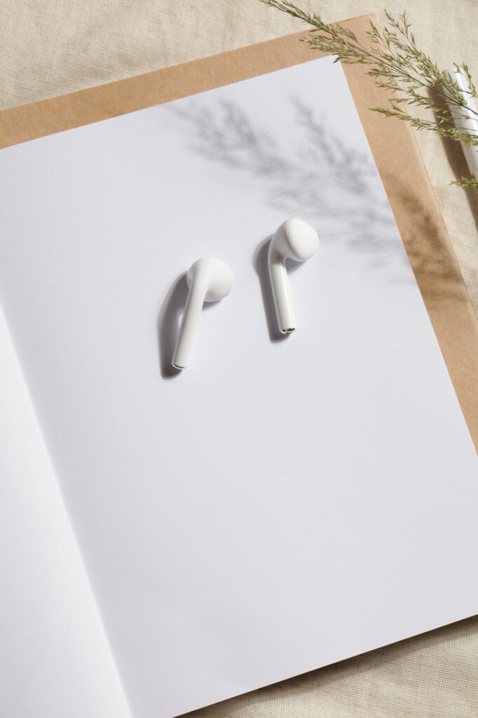 workplace with notebook, pen and headphones on linen textile. Kinfolk designed.